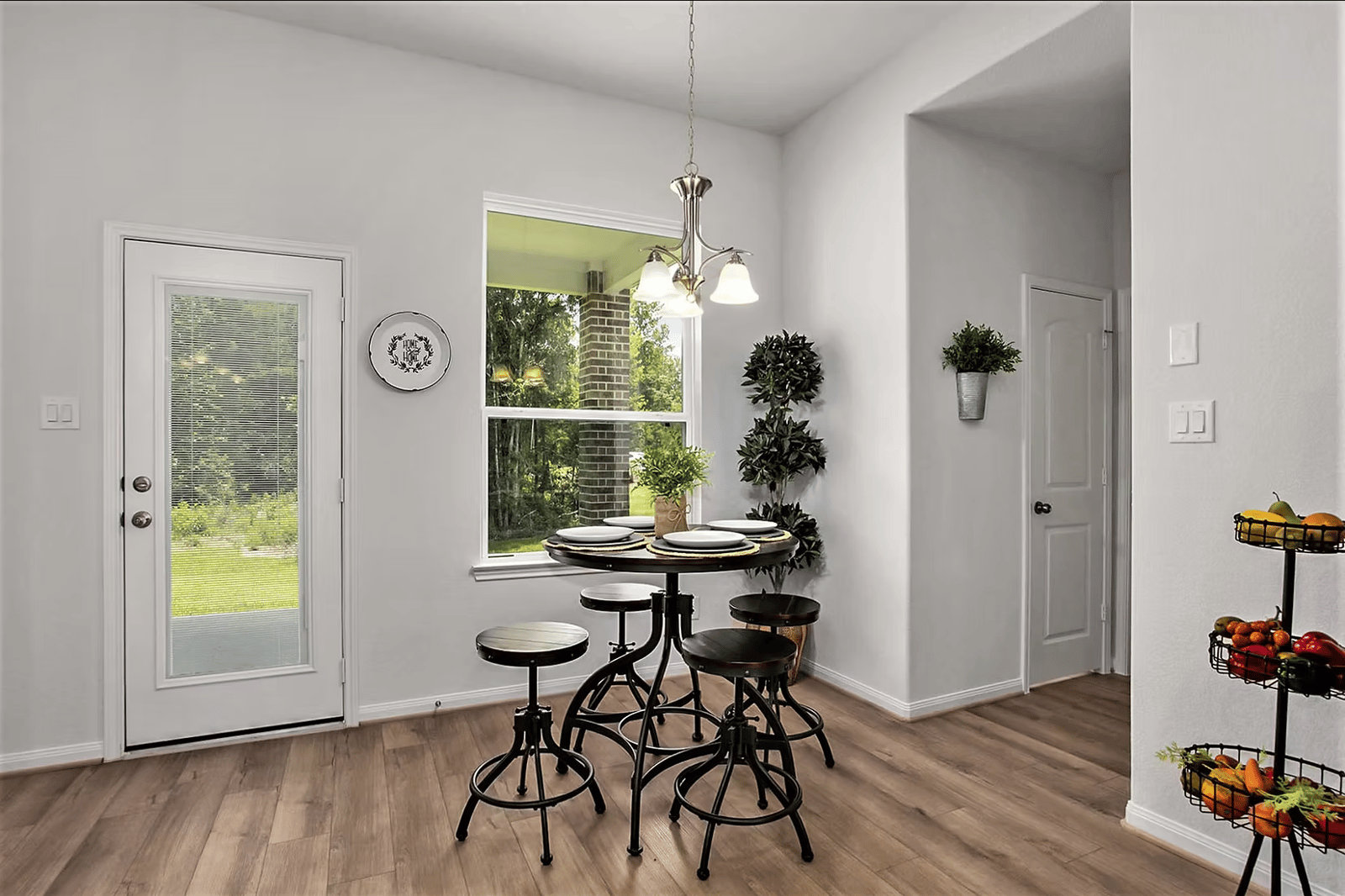 Breakfast nook with a round pedestal table and counter stools beside a window