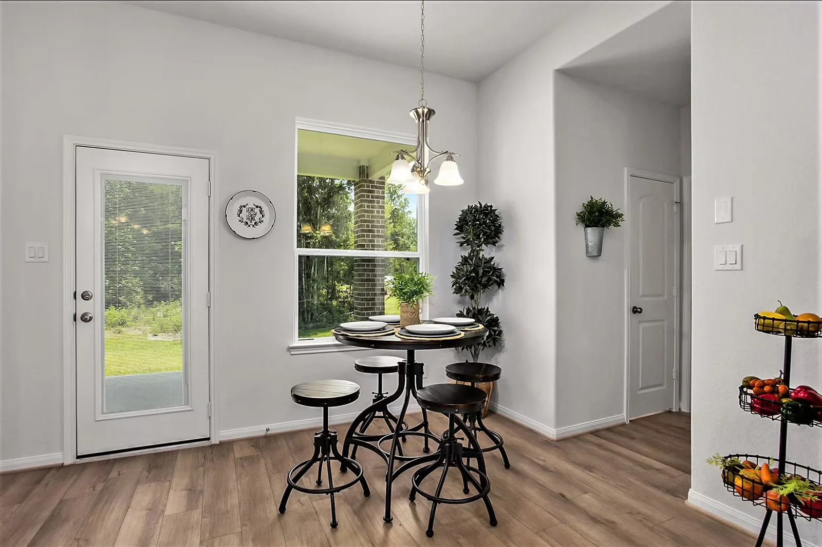Breakfast nook with a round pedestal table and counter stools beside a window