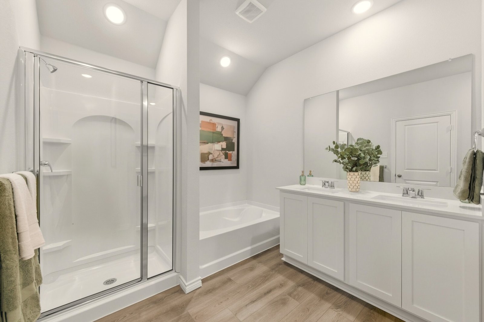 Bathroom with a glass-enclosed shower, a separate soaking tub and a double vanity with white shaker cabinets