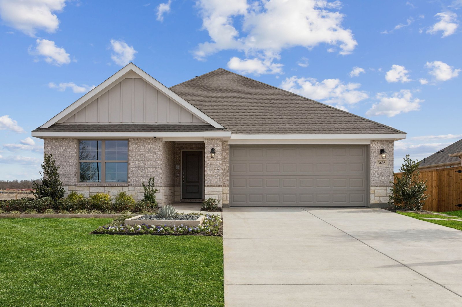 Single-story home exterior with brick and stone masonry and a two-car garage
