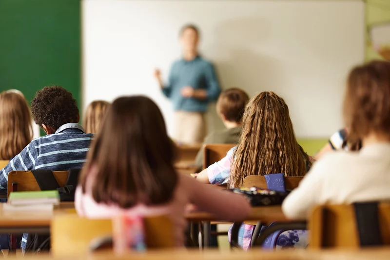 Teacher leading a lesson in front of a class of seated students