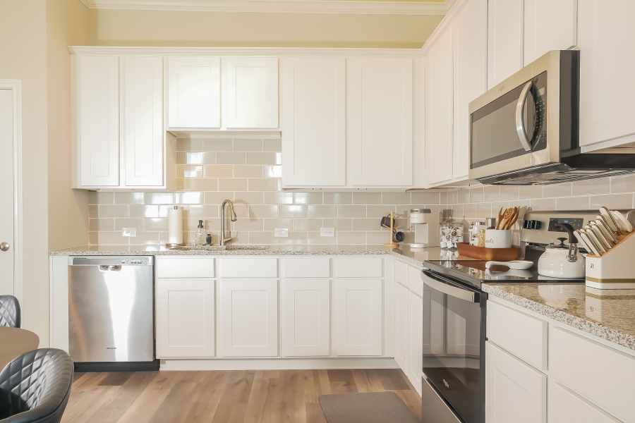 Kitchen with white shaker cabinets, granite worktops, a subway-tile splashback and stainless appliances